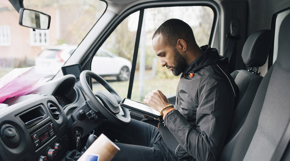delivery driver in a van with a tablet